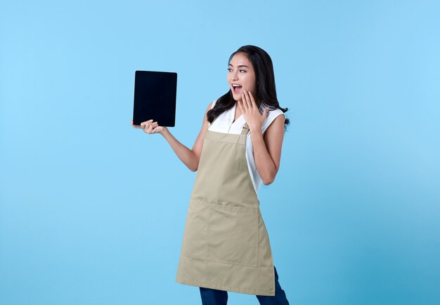 Femme asiatique entrepreneur à l'aide d'un ordinateur tablette sur bleu.