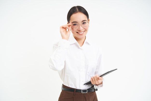 Femme asiatique femme d'affaires professionnelle dans des verres tenant une tablette numérique debout confiant contre