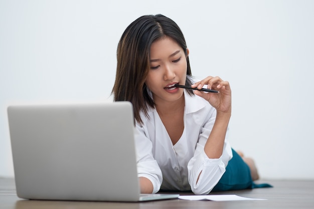 Femme asiatique Jolie Travailler sur le plancher avec un ordinateur portable