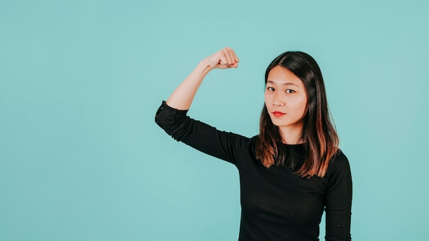 Photo gratuite femme asiatique montrant des muscles