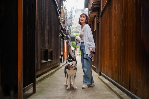 Photo gratuite femme asiatique pleine photo avec un chien mignon