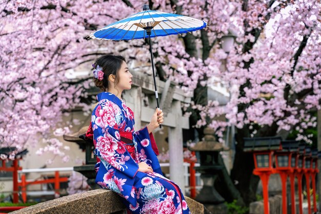 Femme asiatique portant kimono traditionnel japonais et fleur de cerisier au printemps, temple de Kyoto au Japon.