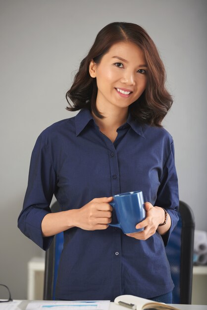 Femme asiatique posant avec une tasse