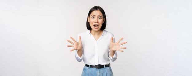 Une femme asiatique regarde la caméra et crie de panique