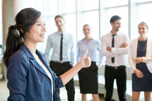 Femme asiatique réussie montrant thumb-up