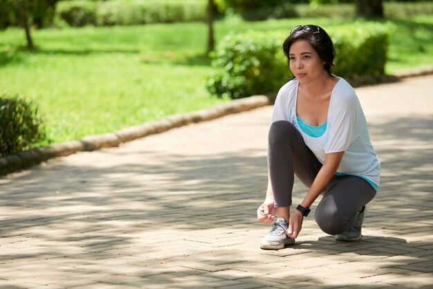 Femme asiatique s'arrêtant en faisant du jogging