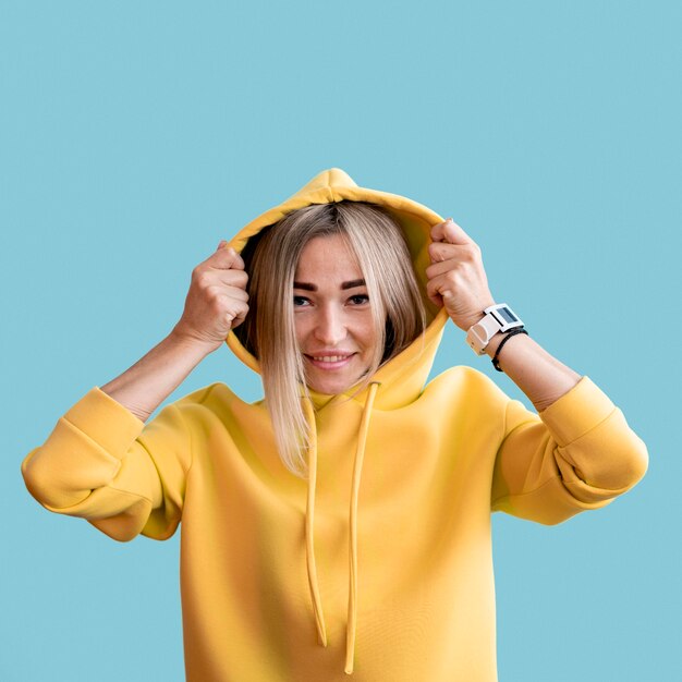 Femme asiatique smiley coup moyen portant un sweat à capuche jaune