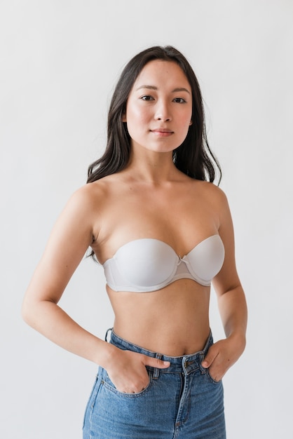 Femme asiatique en soutien-gorge avec les mains dans les poches