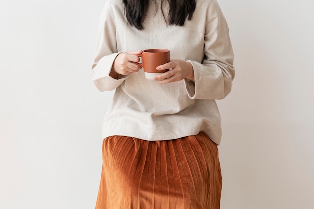 Femme asiatique avec une tasse de café à la main