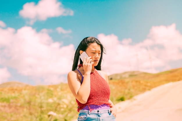 Femme asiatique, téléphoner, marcher, dans, campagne