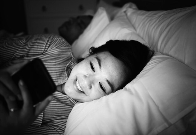 femme asiatique, utilisation, téléphone, sur, a, lit