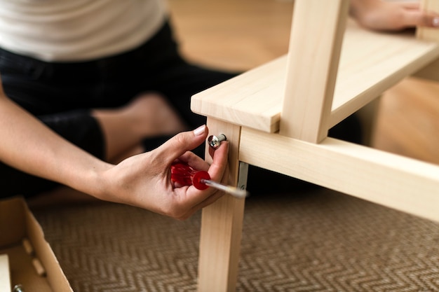 Femme assemblant une chaise de bricolage à partir de zéro