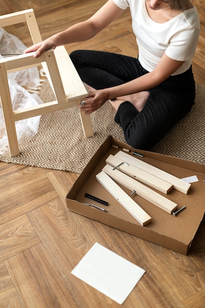 Femme assemblant une chaise de bricolage à partir de zéro