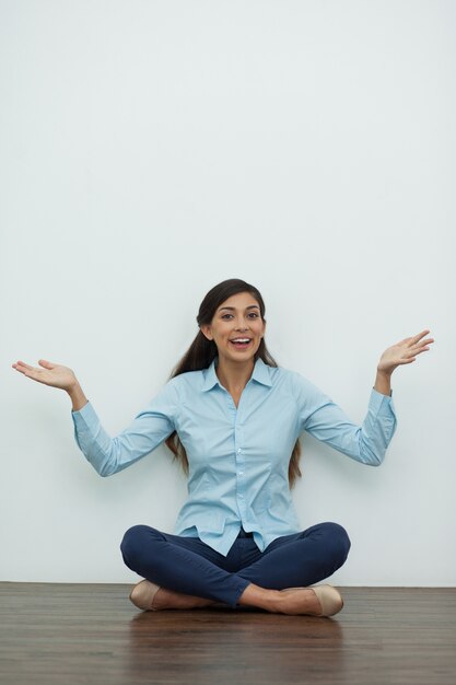 Femme assis sur le plancher, les mains tendues