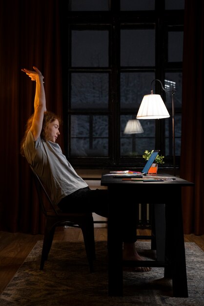 Femme assise au bureau plein coup