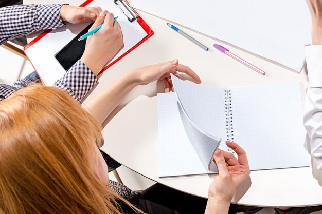 La femme assise au bureau, vérifiant les rapports, parlant.