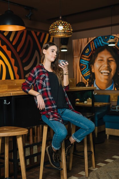 Femme assise sur une chaise avec café au café