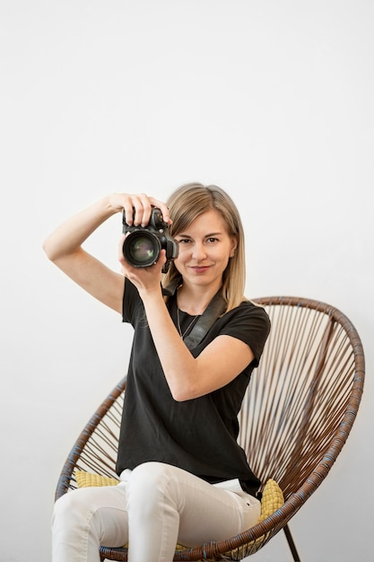 Photo gratuite femme assise sur une chaise et s'apprête à prendre une photo