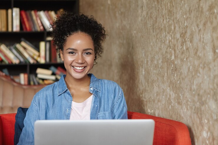 Photo gratuit femme assise dans une bibliothèque avec son ordinateur portable