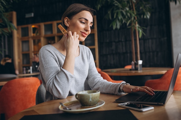 Femme Assise Dans Un Café, Buvant Du Café Et Travaillant Sur Un Ordinateur