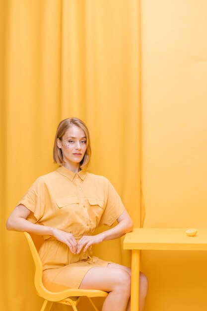 Femme assise dans une scène jaune