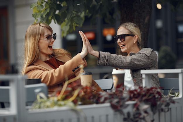 Femme assise dans une ville d'été et boire du café