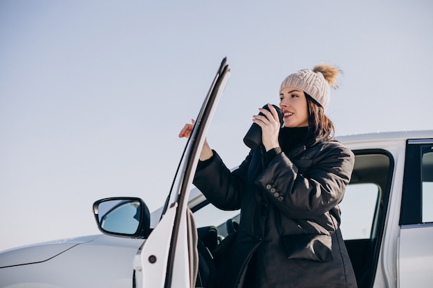 Femme assise dans la voiture et boire du café