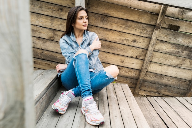 Femme assise sur des escaliers en bois