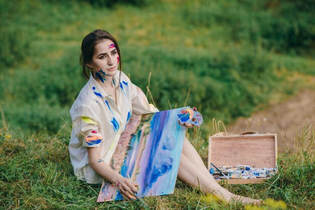 Femme assise sur l&#39;herbe avec une image sur ses jambes