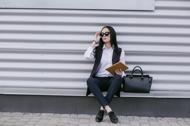 Femme assise sur une marche avec des lunettes de soleil