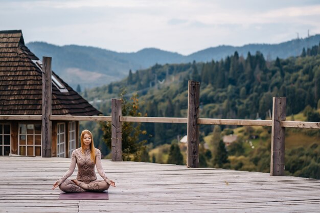 Une femme assise en position du lotus le matin sur un air frais.