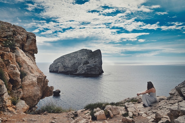 Femme assise près de la mer