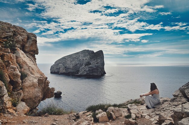 Femme assise près de la mer