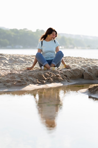Femme assise sur le sable à la plage