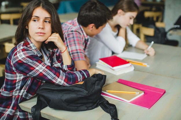 Femme assise à table avec d&#39;autres étudiants