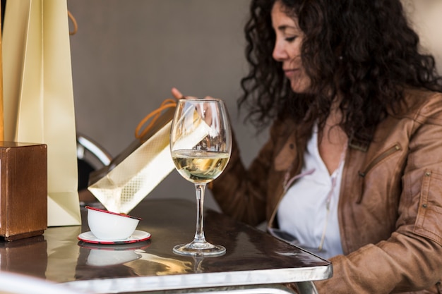 Femme assise à table avec un verre de vin