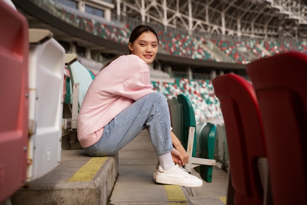 Femme assise sur les tribunes plein coup