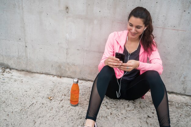 Femme athlétique à l'aide de son téléphone