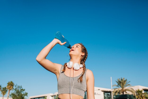 Femme athlétique appréciant la boisson bleue