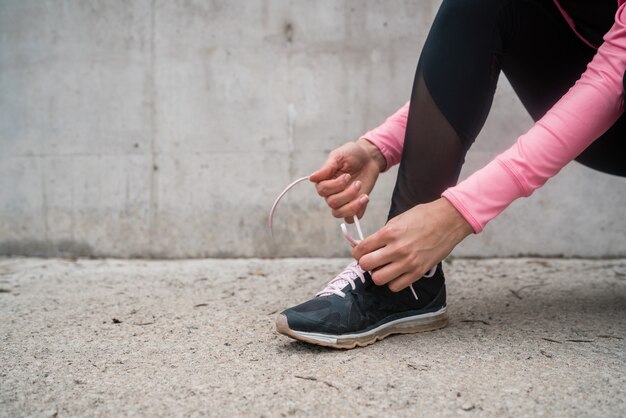 Femme athlétique attachant ses lacets.