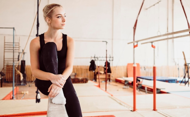 Femme athlétique se détendre après l'entraînement de gymnastique avec espace copie