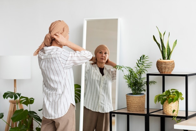 Femme atteinte d'un cancer de la peau se regardant dans le miroir