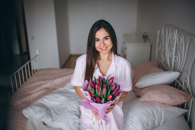 Femme au bouquet de fleurs dans la chambre