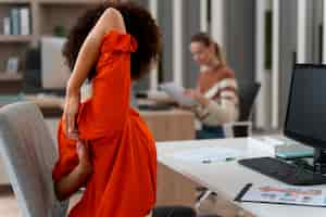 Photo gratuite femme au bureau qui s'étend pendant une journée de travail