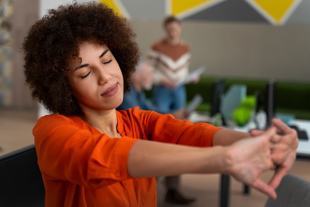 Femme au bureau qui s'étend pendant une journée de travail