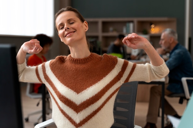 Femme au bureau qui s'étend pendant une journée de travail