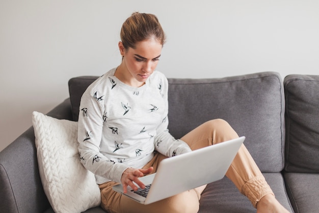 Photo gratuite femme au canapé avec un ordinateur portable