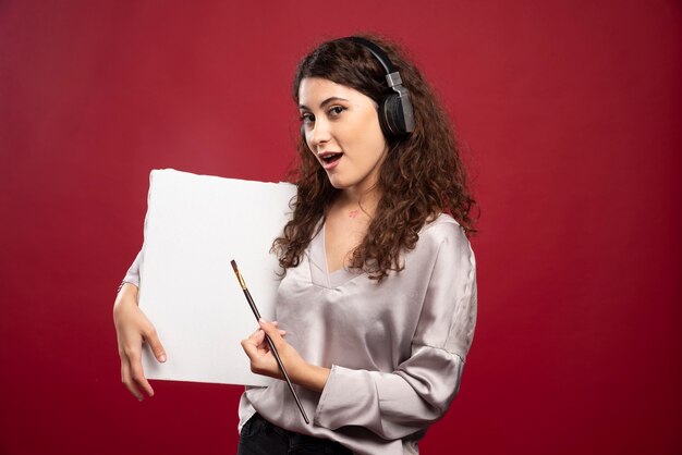 Femme au casque tenant le pinceau et la toile.