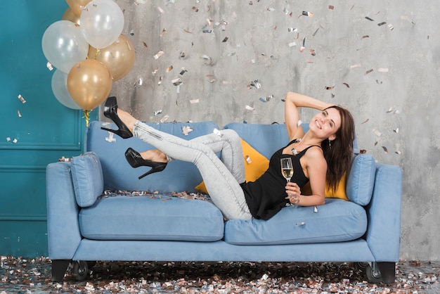 Photo gratuite femme au champagne sur un canapé