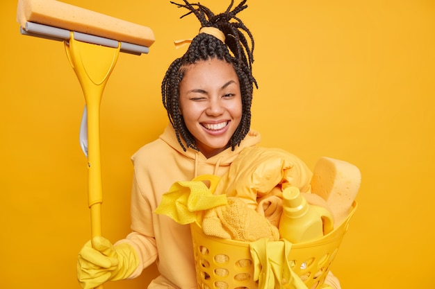 Une femme au foyer afro-américaine positive fait un clin d'œil aux sourires et a une bonne humeur